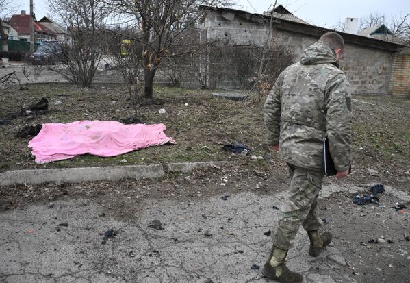 Военнослужащий у трупа сотрудника газовой службы, погибшего в результате обстрелов в Киевском районе Донецка