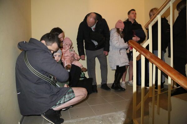 Жильцы многоэтажного жилого дома в Донецке прячутся от обстрела на лестнице в подъезде
