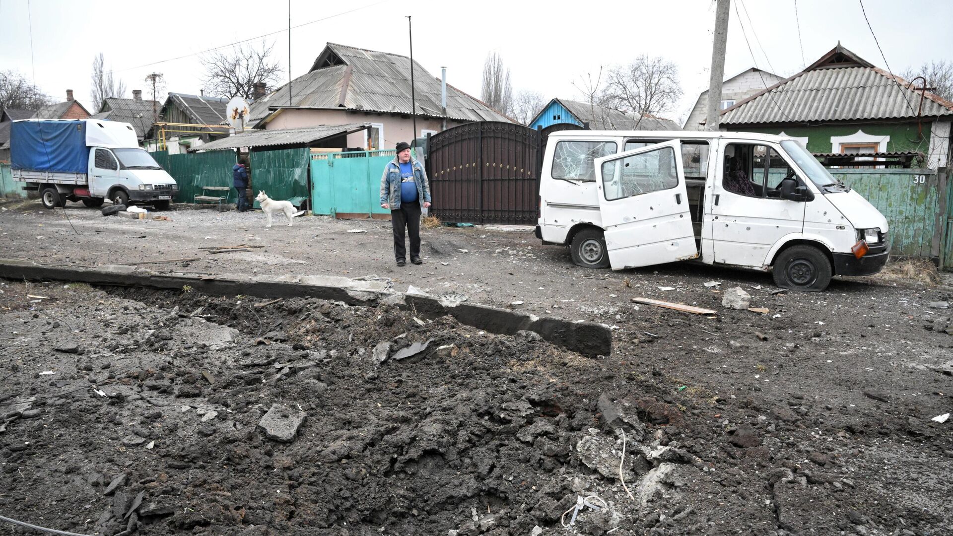 Воронка от взрыва и поврежденный в результате обстрела автомобиль в Киевском районе Донецка - РИА Новости, 1920, 03.03.2022