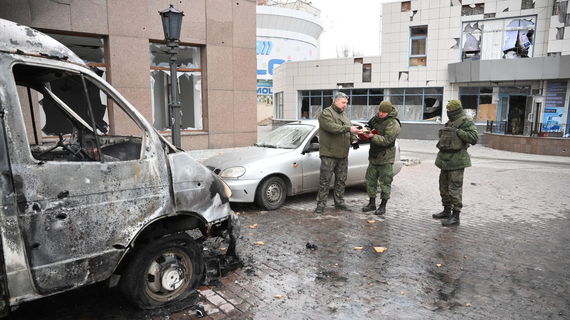 Сотрудники военной комендатуры у сгоревшего в результате обстрелов автомобиля в Киевском районе Донецка - РИА Новости, 1920, 06.03.2022