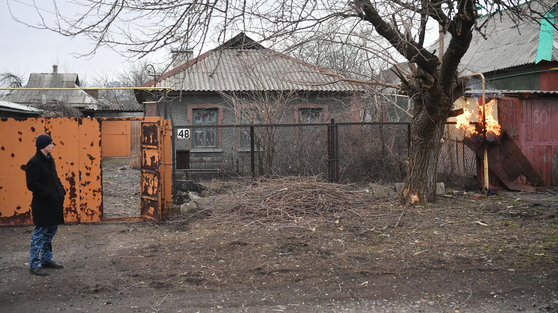 Мужчина около жилого дома в Киевском районе Донецка, поврежденном в результате обстрела - РИА Новости, 1920, 11.03.2022