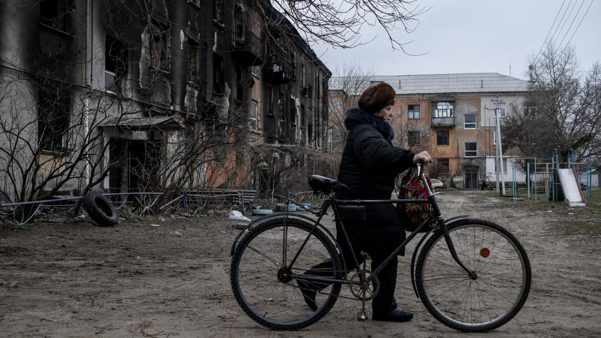 Женщина везет велосипед во дворе жилого дома в городе Счастье в Луганской народной республике - РИА Новости, 1920, 05.03.2022