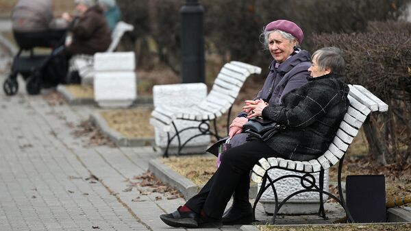 Женщины сидят на скамейке в сквере