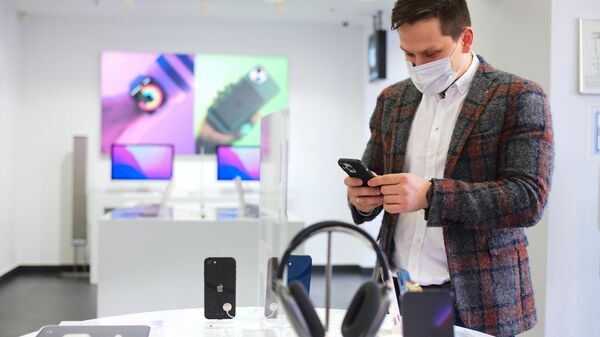 Покупатель выбирает гаджет Apple в магазине ReStore в ГУМе