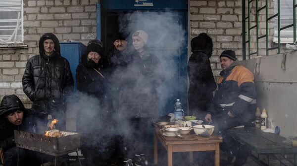 Люди готовят еду у подъезда жилого дома в городе Счастье в Луганской народной республике