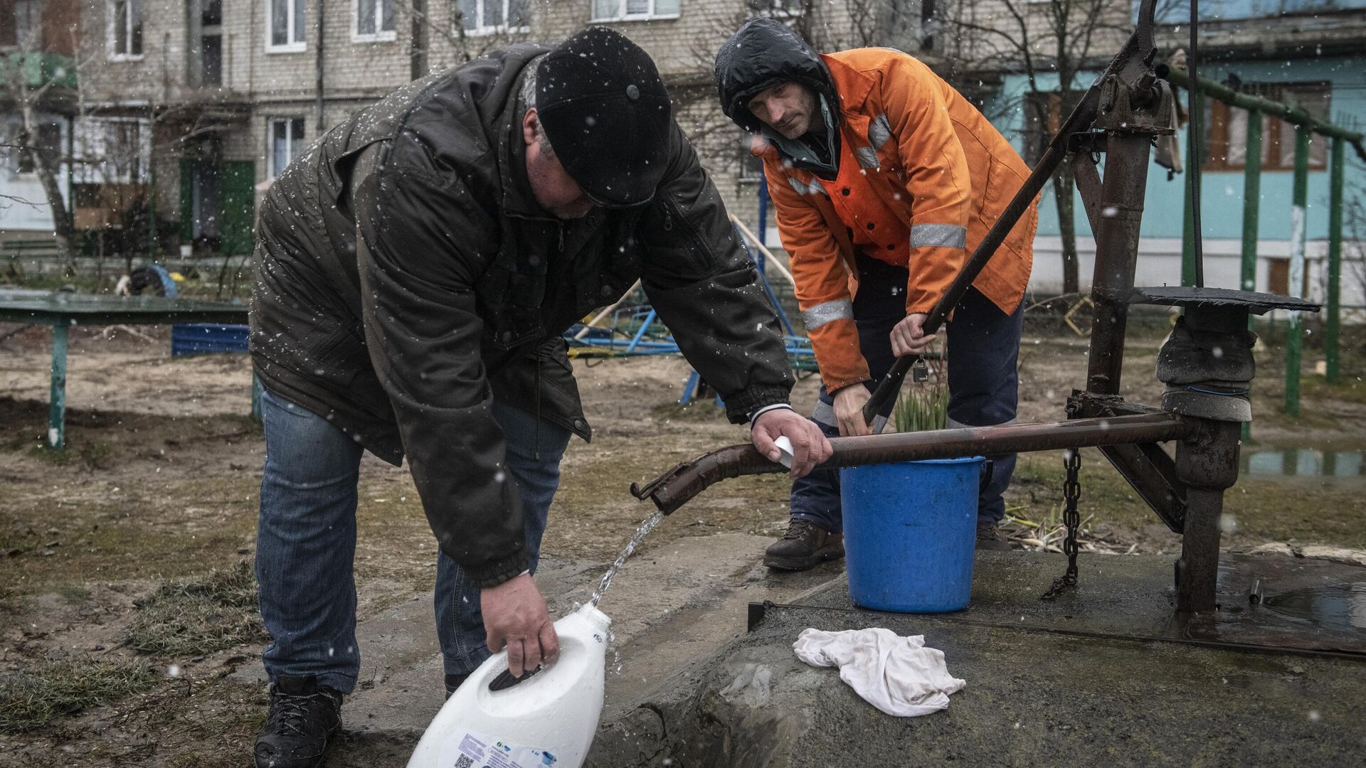 Мужчины набирают воду во дворе жилого дома в городе Счастье в Луганской народной республике - РИА Новости, 1920, 28.03.2022