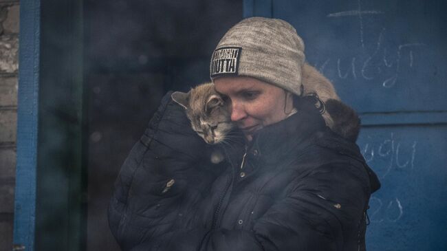 Женщина с котом на улице в освобожденном городе Счастье в Луганской народной республике