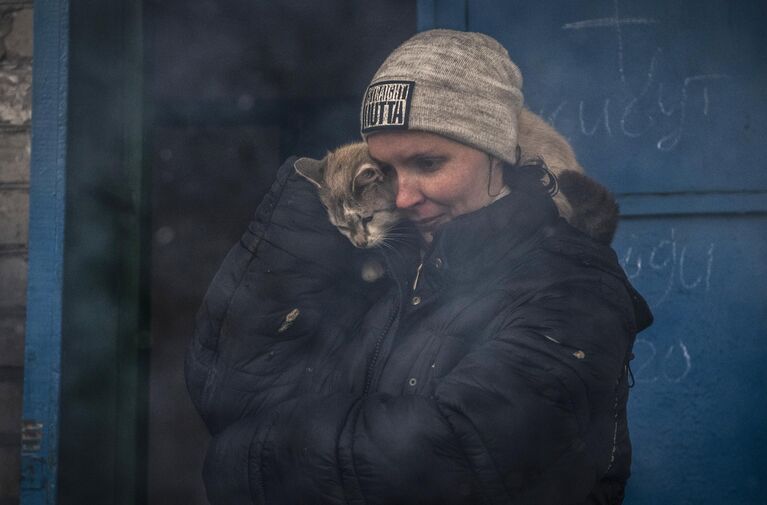 Женщина с котом на улице в освобожденном городе Счастье в Луганской народной республике