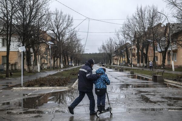 Мужчина с мальчиком на улице в освобожденном городе Счастье в Луганской народной республике