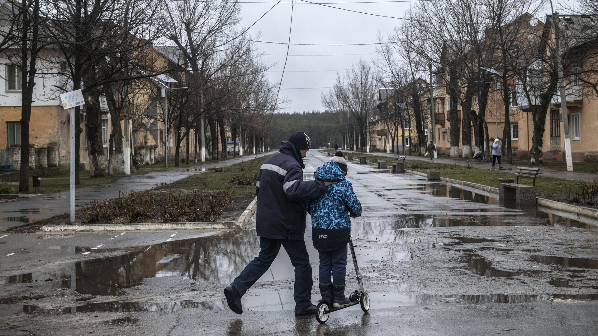 Мужчина с мальчиком на улице в освобожденном городе Счастье в Луганской народной республике - РИА Новости, 1920, 04.04.2022
