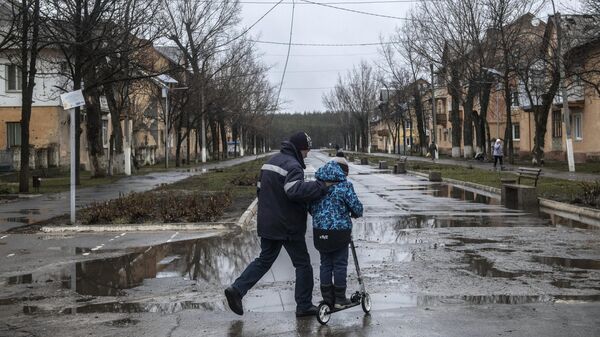Мужчина с мальчиком на улице в освобожденном городе Счастье в Луганской народной республике
