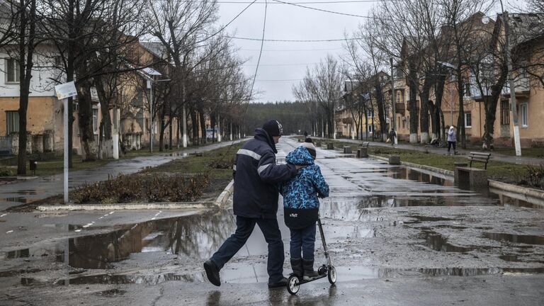 Мужчина с мальчиком на улице в освобожденном городе Счастье в Луганской народной республике