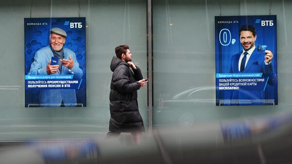 Мужчина возле витрины банка ВТБ в Москве
