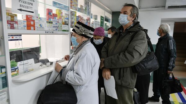 Люди в медицинских масках стоят в очереди в аптеку