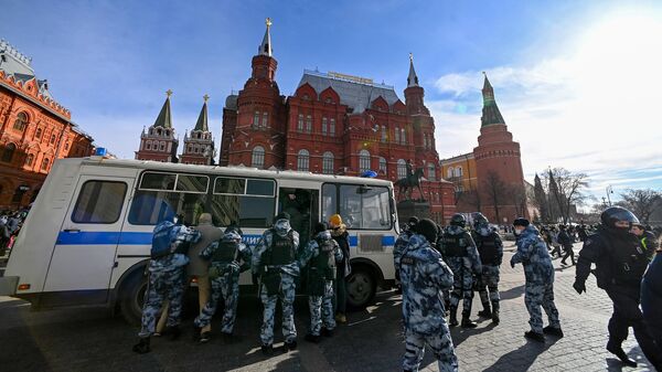 Сотрудники полиции заводят в автозак людей, задержанных на несанкционированной акции против военной операции на Украине на Манежной площади в Москве
