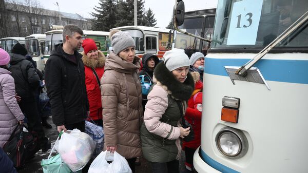 Люди заходят в автобус во время эвакуации из Горловки на территорию России