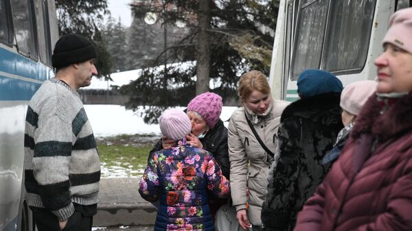 Люди прощаются возле автобуса во время эвакуации из Горловки в Россию