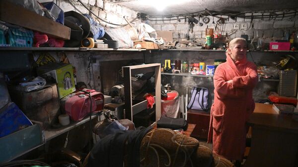 Женщина прячется в подвале дома от обстрела ВСУ поселка шахты имени Гагарина в Горловке