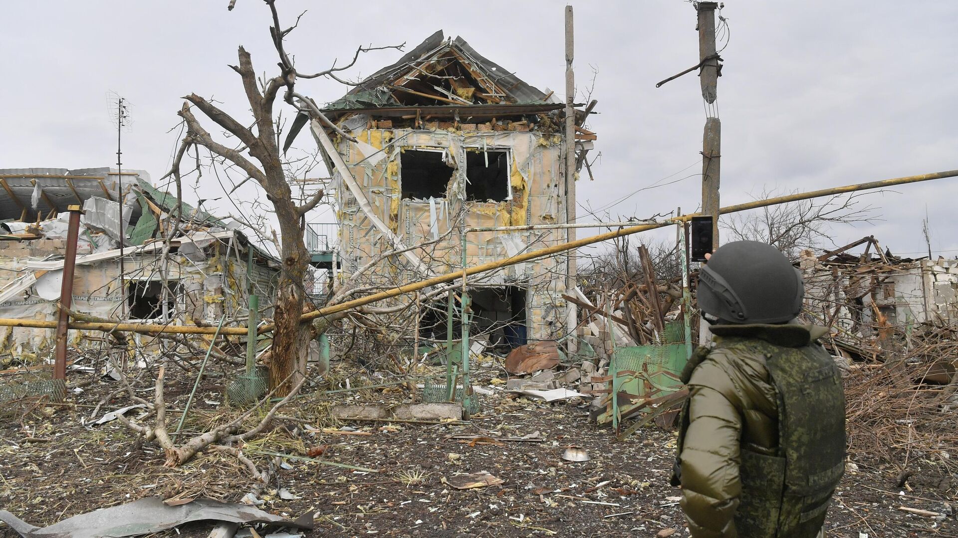 Мужчина фотографирует один из разрушенных домов села Сопино в Донецкой народной республике - РИА Новости, 1920, 09.03.2022