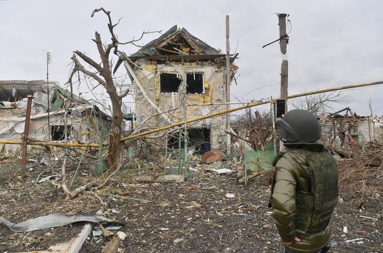 Мужчина фотографирует один из разрушенных домов села Сопино в Донецкой народной республике