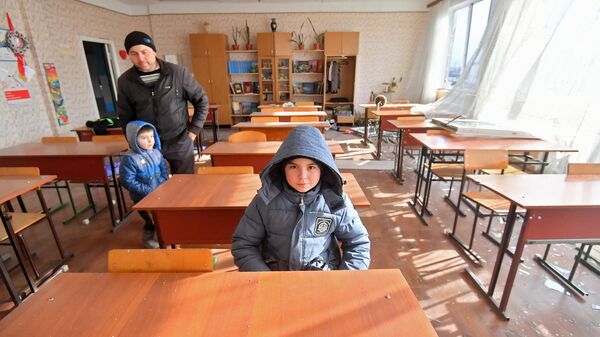 Мужчина с детьми в одном из классов специализированной школы с углублённым изучением новогреческого языка в поселке Сартана в Донецкой народной республике