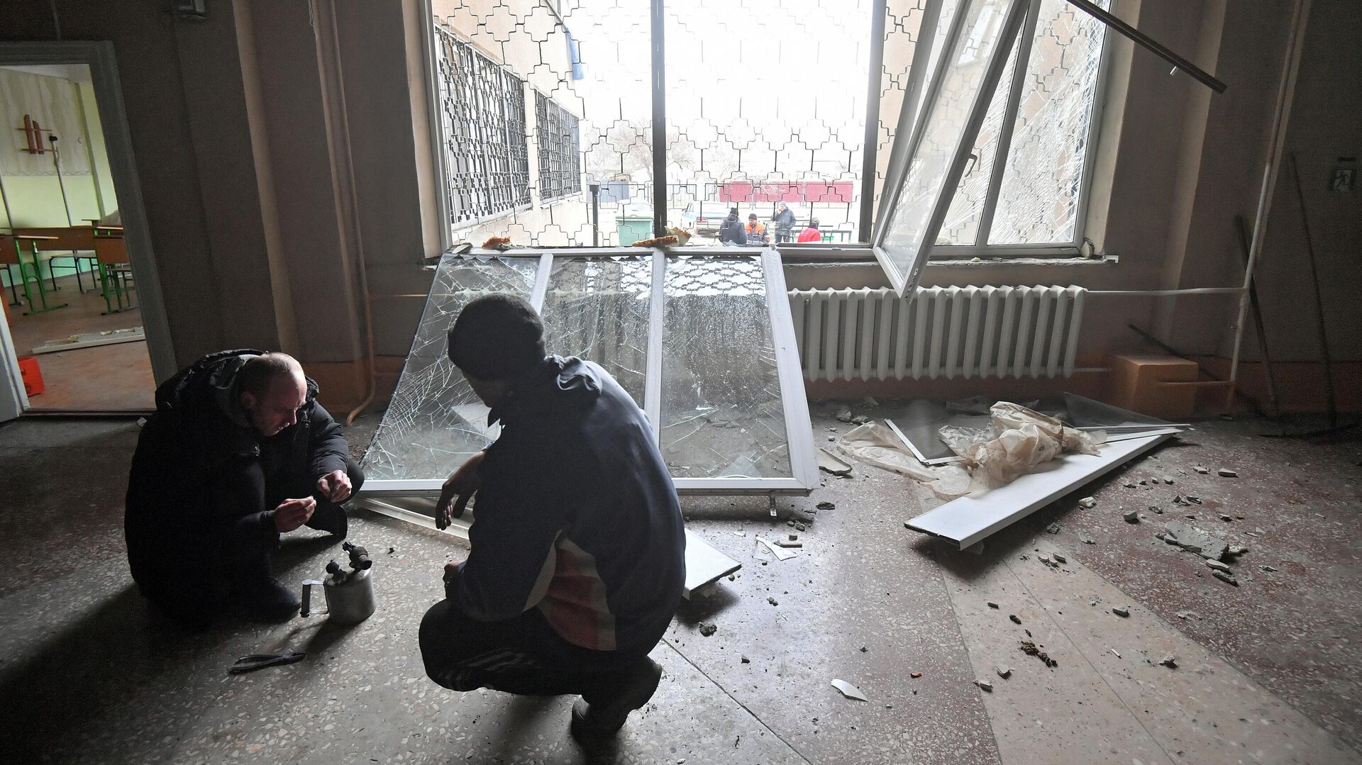 Мужчины ремонтируют выбитые взрывами окна в Донецкой народной республике - РИА Новости, 1920, 14.03.2022