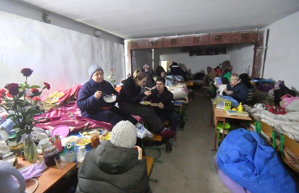 Местные жители, живущие в бомбоубежище в подвале специализированной школы с углубленным изучением новогреческого языка в поселке Сартана в Донецкой народной республике