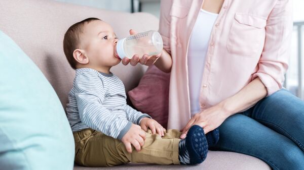 Младенец пьет из бутылочки