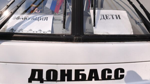 Автобус с табличками Эвакуация и Дети у пункта оказания помощи эвакуированному населению в селе Безыменное Новоазовского района