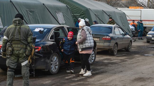 Беженцы из Мариуполя у палаток пункта оказания помощи эвакуированному населению в селе Безыменное