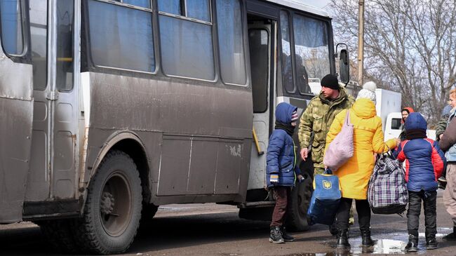 Беженцы из Мариуполя у пункта оказания помощи эвакуированному населению в селе Безыменное