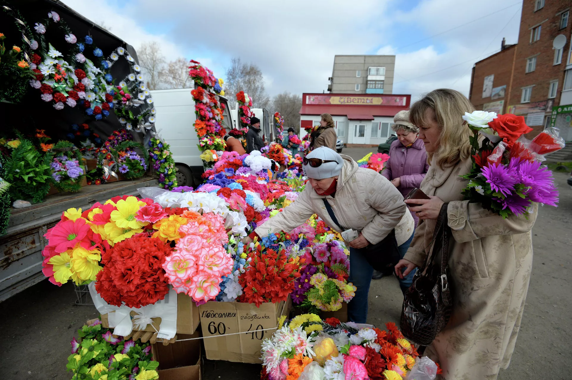 Женщины покупают искусственные цветы на рынке в городе Тара Омской области в День поминовения (Радоница) - РИА Новости, 1920, 10.01.2023