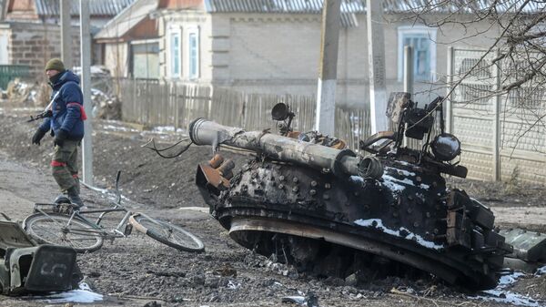 Боец Народной милиции ДНР у фрагмента подбитого и сгоревшего танка Вооруженных сил Украины