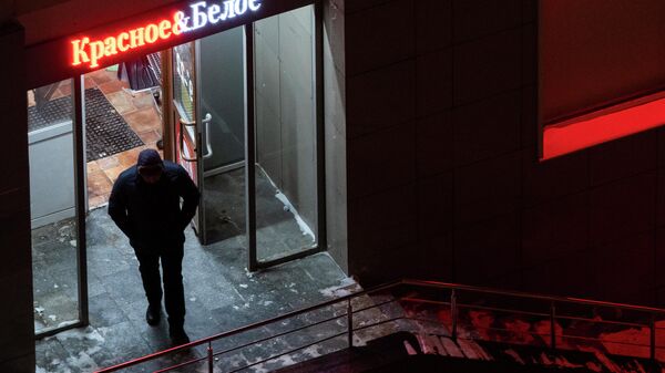 Мужчина выходит из магазина Красное & Белое в Москве