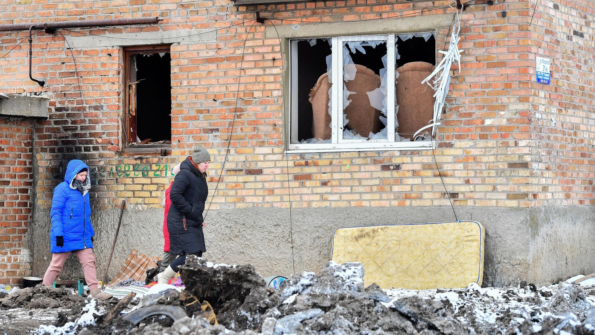 Жители Волновахи идут рядом с разрушенным домом - РИА Новости, 1920, 21.03.2022