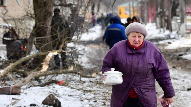 Жительница Волновахи идет по улице с кастрюлей