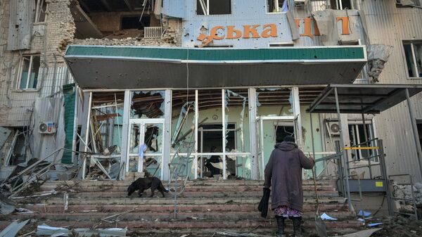 Женщина у здания городской больницы, разрушенного в результате обстрела со стороны ВСУ