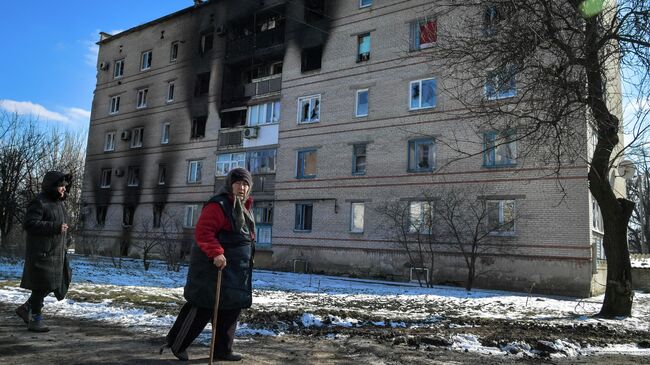 Женщины около дома, поврежденного в результате обстрела в микрорайоне Северный в Волновахе