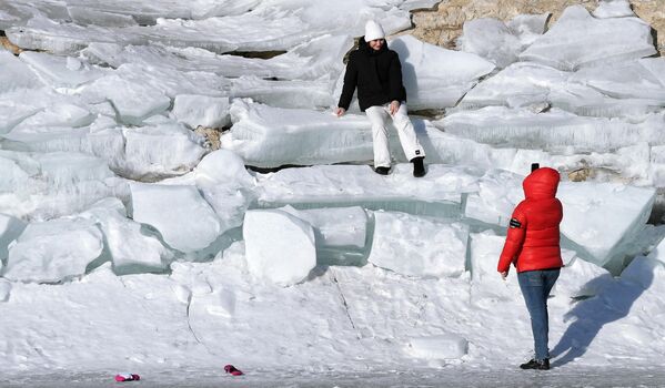 Девушки фотографируются на покрытом льдом берегу Бирюсинского залива Красноярского водохранилища 