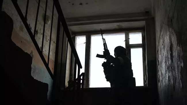 Военнослужащий осматривает здание казарм брошенной артиллерийской части Вооруженных сил Украины в Бердянске