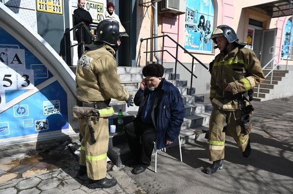 Сотрудники МЧС РФ оказывают помощь мужчине на месте взрыва в центре Донецка