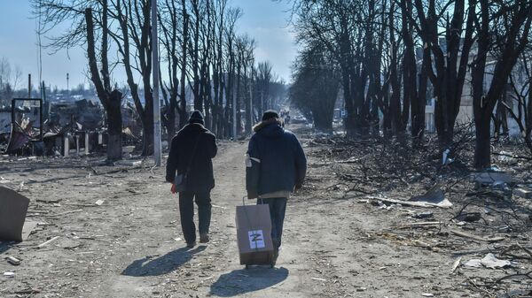 Местные жители везут полученную гуманитарную помощь на улице в перешедшем под контроль ДНР городе Волноваха