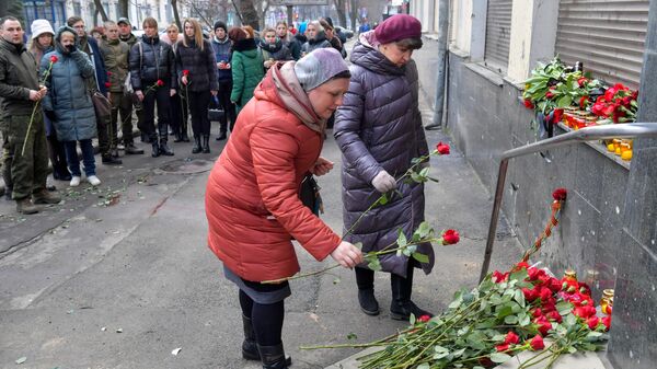 Жители возлагают цветы к месту гибели людей от обстрела в Донецке