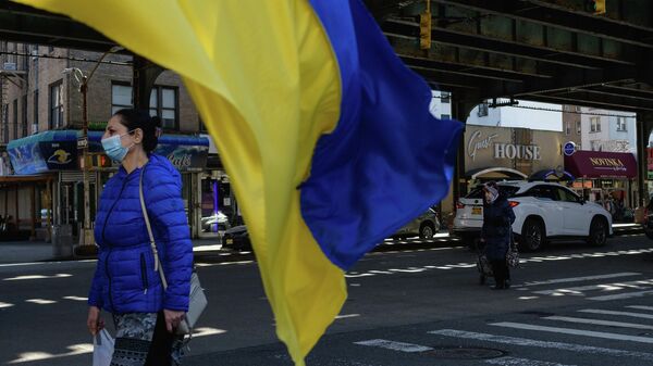 Женщина проходит мимо украинского флага на Брайтон-Бич в Нью-Йорке