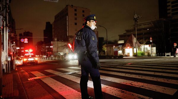 Полицейский контролирует движение во время отключения электроэнергии после землетрясения в Токио, Япония