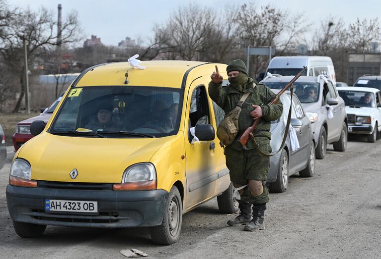 Военнослужащий НА ДНР указывает дорогу беженцам на автомобиле покидающим Мариуполь