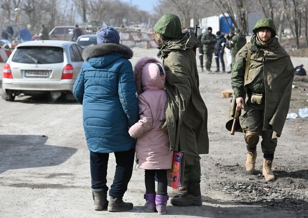 Военнослужащий НА ДНР общается с беженцами на выезде из Мариуполя