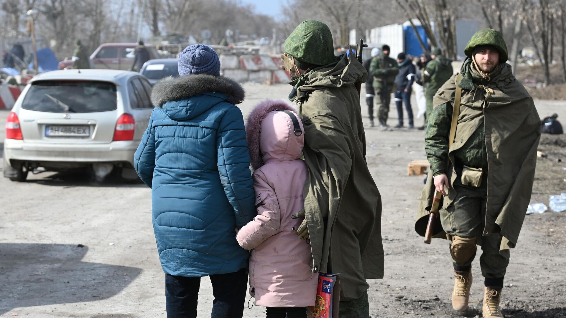 Военнослужащий НА ДНР общается с беженцами на выезде из Мариуполя - РИА Новости, 1920, 17.03.2022