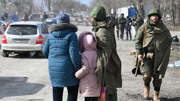 Военнослужащий НА ДНР общается с беженцами на выезде из Мариуполя
