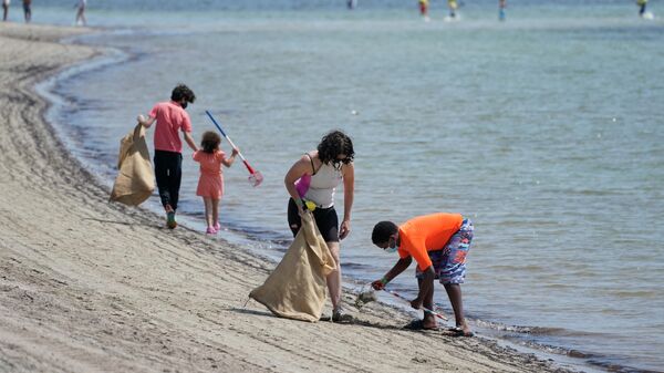 Волонтеры, собирают мусор во время уборки пляжа в честь Дня Земли, Флорида